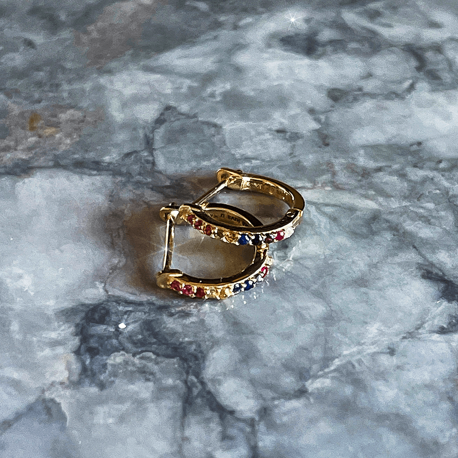 Rainbow Sapphire and Diamond Huggie Earring on Marble Surface