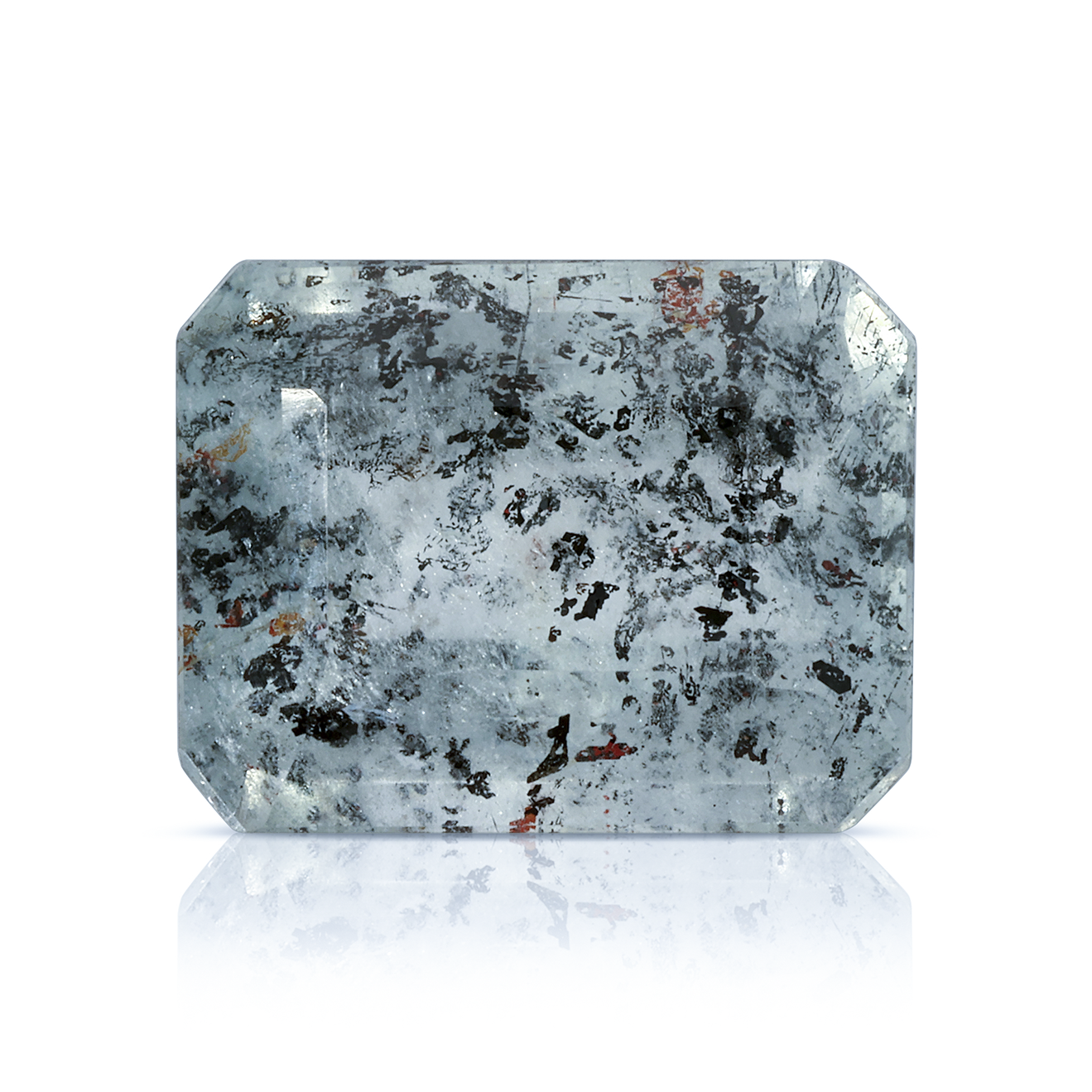 Emerald-cut Leopard Aquamarine gemstone with hematite and iron inclusions on a white reflective background.