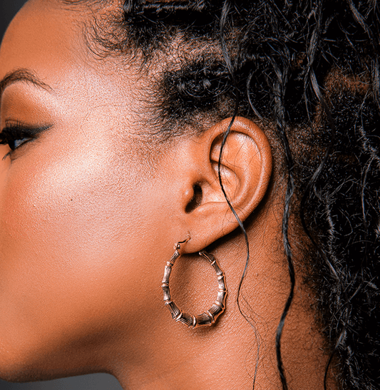 Side view of Black model with boho locs wearing real gold bamboo earrings