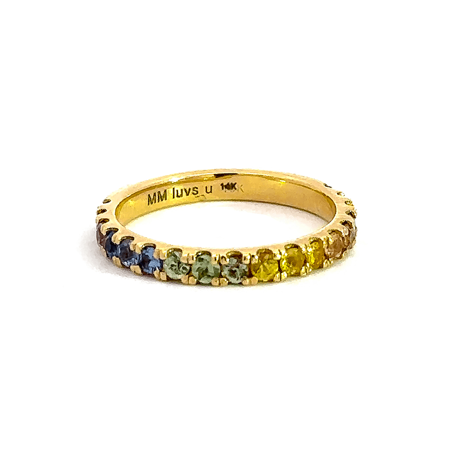 rainbow sapphire stones set on gold band on a white background